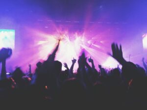 people at concert. Purple colour lights and people dancing at music